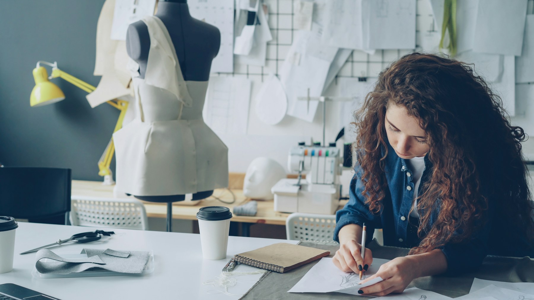 Fashion product development workspace with garment sketches and dress forms